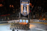 LAS VEGAS, NEVADA - OCTOBER 10:  The Vegas Golden Knights pose for a team photo in front of the 2023 Stanley Cup championship banner that is raised from of a prop slot machine on the ice during a ceremony before the Vegas Golden Knights' home opener against the Seattle Kraken at T-Mobile Arena on October 10, 2023 in Las Vegas, Nevada.  (Photo by Candice Ward/Getty Images)