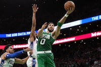 Boston Celtics forward Jayson Tatum (0) shoots at the basket as Philadelphia 76ers forward Tobias Harris, left, and guard De'Anthony Melton, behind center, defend during the second half of Game 7 in the NBA basketball Eastern Conference semifinal playoff series, Sunday, May 14, 2023, in Boston. (AP Photo/Steven Senne)