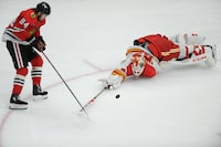 Calgary Flames goalie Jacob Markstrom (25) battles Chicago Blackhawks' Landon Slaggert (84) for a loose puck during the second period of an NHL hockey game Tuesday, March 26, 2024, in Chicago. (AP Photo/Paul Beaty)