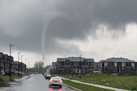 A funnel cloud is shown in Barrhaven, Ont., just outside of Ottawa on Thursday, July 13, 2023. A tornado touched down in a suburb in the south end of Ottawa, police said Thursday, as they advised residents to seek shelter from the storm. THE CANADIAN PRESS/Handout