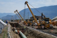 Workers lay pipe during construction of the Trans Mountain pipeline expansion, in Abbotsford, B.C., on Wednesday, May 3, 2023. The Canada Energy Regulator is slated to hear oral arguments Friday from the company building the Trans Mountain pipeline expansion on its request for a pipeline variance.THE CANADIAN PRESS/Darryl Dyck