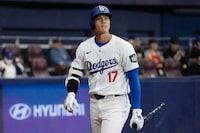 Los Angeles Dodgers' designated hitter Shohei Ohtani walks after he was struck out in the first inning during the exhibition game between the Los Angeles Dodgers and Kiwoom Heroes at the Gocheok Sky Dome in Seoul, South Korea, Sunday, March 17, 2024. The Los Angeles Dodgers and the San Diego Padres will meet in a two-game series on March 20th-21st in Seoul for the MLB World Tour Seoul Series. (AP Photo/Ahn Young-Joon)