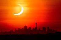 Municipalities across Central and Eastern Canada have spent months preparing for an event that will last less than a few: a total solar eclipse that will cast parts of the country into complete darkness. An annular solar eclipse rises over the skyline of Toronto on Thursday, June 10, 2021. THE CANADIAN PRESS/Frank Gunn