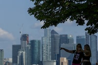 People look out from Greenwich Park, with Canary Wharf in the distance, in London, Britain June 22, 2023.