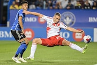 CF Montreal's Mathieu Choiniere, left, challenges New England Revolution's Noel Buck during first half MLS soccer action in Montreal, Saturday, August 26, 2023. THE CANADIAN PRESS/Graham Hughes 