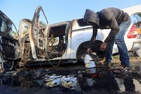 A Palestinian inspects near a vehicle where employees from the World Central Kitchen (WCK), including foreigners, were killed in an Israeli airstrike, according to the NGO as the Israeli military said it was conducting a thorough review at the highest levels to understand the circumstances of this "tragic" incident, amid the ongoing conflict between Israel and Hamas, in Deir Al-Balah, in the central Gaza, Strip April 2, 2024. REUTERS/Ahmed Zakot