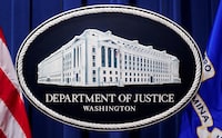 FILE PHOTO: A U.S. Justice Department logo or seal showing Justice Department headquarters, known as "Main Justice," is seen behind the podium in the Department's headquarters briefing room before a news conference with the Attorney General in Washington, January 24, 2023.  REUTERS/Kevin Lamarque/File Photo