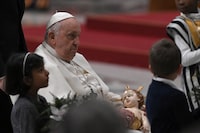 Pope Francis holds a figurine of baby Jesus during the Christmas Eve mass at St. Peter's Basilica in the Vatican on December 24, 2023. (Photo by Tiziana FABI / AFP) (Photo by TIZIANA FABI/AFP via Getty Images)