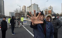 Plainclothes police officers gesture to signify photographs should not be taken in front of the number 2 intermediate people's court in Tianjin on December 26, 2018, where the trial of human rights lawyer Wang Quanzhang is set to begin. - Two rights activists were taken away on December 26 after protesting outside the courthouse where the trial of Wang, a prominent human rights lawyer, is set to begin amid tight security, according to an AFP reporter and a witness. (Photo by Nicolas ASFOURI / AFP)NICOLAS ASFOURI/AFP/Getty Images