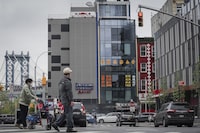 A six story glass facade building, center, is believed to be the site of a foreign police outpost for China in New York's Chinatown, Monday, April 17, 2023. Justice Department officials say two men have been arrested on charges that they helped establish a secret police outpost in New York City on behalf of the Chinese government. (AP Photo/Bebeto Matthews)