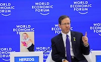 A picture of a child, Kfir Bibas, who has been taken hostage by Palestinian Islamist group Hamas is placed next to Israeli President Isaac Herzog, as he attends the 54th annual meeting of the World Economic Forum, in Davos, Switzerland, January 18, 2024. REUTERS/Denis Balibouse