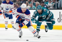SAN JOSE, CALIFORNIA - DECEMBER 28: Ryan McLeod #71 of the Edmonton Oilers skates up ice with the puck pursued by Justin Bailey #90 of the San Jose Sharks during the third period at SAP Center on December 28, 2023 in San Jose, California. (Photo by Thearon W. Henderson/Getty Images)