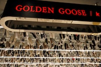 Sneakers of Italian high-fashion sneaker brand Golden Goose are hung near its sign at its store in Beijing, China, September 23, 2020.