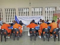 Inmates at the all-male Zonderwater Correctional Centre on the outskirts of Pretoria, South Africa, wait Thursday Feb. 1, 2024, to register as voters or update their details on electoral rolls. The Electoral Commission of South Africa says it hopes to significantly increase the number of prisoners who take part in this year's national election. (AP Photo/Sebabatso Mosamo)