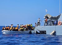 This image provided from Cyprus' Joint rescue Coordination Center shows Cyprus' rescue team helping migrants from a boat in the sea near the eastern coastal resort of Protaras, on the east side of the Mediterranean island of Cyprus, on Sunday, Aug. 21, 2023. Cyprus police have rescued 18 Syrian migrants after their boat started taking on water some 3.5 miles off the southeastern coast. Police said the 11 men, three unescorted minors, one woman and her three children had set sail from Tartus, Syria and were brought ashore aboard a police patrol vessel.  (Joint Rescue Coordination Center via AP)