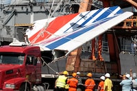 FILE - Workers unloading debris, belonging to crashed Air France flight AF447, from the Brazilian Navy's Constitution Frigate in the port of Recife, northeast of Brazil, Sunday, June 14, 2009. A French court is ruling Monday April 17, 2023 on whether Airbus and Air France are guilty of manslaughter over the 2009 crash of Flight 447 en route from Rio to Paris, which killed 228 people and led to lasting changes in aircraft safety measures. (AP Photo/Eraldo Peres, File)