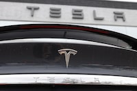 The company logo shines off the rear deck of a 2020 Model X at a Tesla dealership in Littleton, Colo., on April 26, 2020. American prosecutors say a Canadian citizen living in China stole trade secrets from a "leading U.S.-based electric vehicle company" to set up a competing battery business. THE CANADIAN PRESS/AP-David Zalubowski