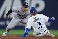 New York Yankees shortstop Anthony Volpe (11) tags out Toronto Blue Jays' Justin Turner (2) on a steal attempt at second base during fifth inning American League MLB baseball action in Toronto on Tuesday, April 16, 2024. THE CANADIAN PRESS/Nathan Denette