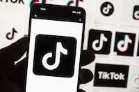 FILE - The TikTok logo is displayed n a mobile phone in front of a computer screen displaying the TikTok home screen, Oct. 14, 2022, in Boston. In a lawsuit filed Tuesday, April 9, 2024, two tribal nations accused social media companies — including Facebook and Instagram’s parent company Meta Platforms; Snapchat's Snap Inc.; TikTok parent company ByteDance; and Alphabet, which owns YouTube and Google — of contributing to the disproportionately high rates of suicide among Native American youth. (AP Photo/Michael Dwyer, File)
