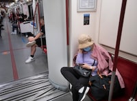 A TTC subway passenger uses their mobile phone while heading north on the Yonge line on Aug 21, 2023. (Fred Lum/The Globe and Mail)