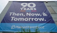 FILE PHOTO: A "90 years of service" poster hangs on the side of Planned Parenthood after the United States Supreme Court ruled in the Dobbs v Women's Health Organization abortion case, overturning the landmark Roe v Wade abortion decision, in St. Louis, Missouri, U.S. June 24, 2022.  REUTERS/Lawrence Bryant/File Photo