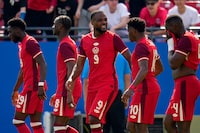 Canada's Alphonso Davies (19), Ismael Kone (8), Cyle Larin (9), Jonathan David (10) and Kamal Miller (4) celebrate after Larin scored in the second half of a CONCACAF Nations League Play-In soccer match against Trinidad And Tobago, Saturday, March 23, 2024, in Frisco, Texas. (AP Photo/Julio Cortez)