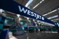 A WestJet logo is seen in the domestic check-in area at Vancouver International Airport, in Richmond, B.C., on Friday, May 19, 2023.The union representing WestJet cabin crew is demanding an apology from the airline after Conservative Leader Pierre Poilievre delivered a speech on the public address system of a recent flight.&nbsp;THE CANADIAN PRESS/Darryl Dyck
