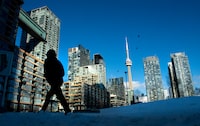 Condo towers dot the Toronto skyline as a pedestrian makes his way through the COVID-19 restricted winter landscape on Thursday January 28, 2021. CMHC says that rental vacancies are up in Canada’s largest cities with rents rising too. THE CANADIAN PRESS/Frank Gunn