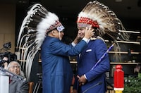 Manitoba Premier designate Wab Kinew, receives a War Bonnet from his uncle prior to a Premier and cabinet swearing-in ceremony in Winnipeg, Wednesday, Oct. 18, 2023. THE CANADIAN PRESS/John Woods