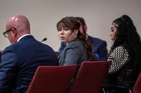Hannah Gutierrez-Reed, center, sits with her attorney Jason Bowles, left, during the first day of testimony in the trial against her in First District Court, in Santa Fe, N.M., Thursday, February 22, 2024. Gutierrez-Reed, who was working as the armorer on the movie "Rust" when a revolver actor Alec Baldwin was holding fired killing cinematographer Halyna Hutchins and wounded the film’s director Joel Souza, is charged with involuntary manslaughter and tampering with evidence. (Eddie Moore/Santa Fe New Mexican via AP, Pool)