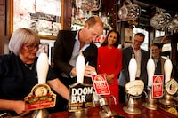 Britain's Prince William pulls the first pint of 'Kingmaker', a new brew celebrating the coronation, as Catherine Princess of Wales looks on while they visit the Dog and Duck pub in Soho ahead of this weekend's coronation, in London, Britain May 4, 2023. Jamie Lorriman/Pool via REUTERS     TPX IMAGES OF THE DAY