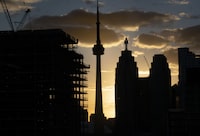 A condominium development (L), the CN Tower and office buildings in Toronto’s Financial District are silhouetted as the sun sets on Nov 7, 2022. Fred Lum/The Globe and Mail. 