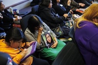 Dorothy Sakanee, second from left, hangs her head as she holds a photo of her granddaughter Mackenzie Moonias, a 14-year-old found dead in Thunder Bay in December, 2023, during a press conference calling for the disbandment of the Thunder Bay Police Services at Queens Park in Toronto, Monday, April 22, 2024. THE CANADIAN PRESS/Cole Burston