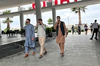Afghan men walk at a tourist resort where they are accommodated, in Shengjin, 70 kilometer (44 mile) northwest of the capital, Tirana,  Albania, Tuesday, June 6, 2023. Hundreds of Afghans are languishing in Albania, waiting for the U.S. visas they were promised, almost two years after fleeing the Taliban takeover of their country. For many, it's an emotional roller coaster. (AP Photo/Llazar Semini)