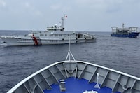 FILE - A Chinese coast guard ship, left, with a Chinese militia vessel, right, blocks Philippine coast guard ship, BRP Sindangan as it tried to head towards Second Thomas Shoal at the disputed South China Sea during rotation and resupply mission on Oct. 4, 2023. A Chinese coast guard ship and one of its militia vessels separately bumped a Philippine coast guard ship and a military-run supply boat Sunday, Oct. 22 off a disputed shoal, Philippine officials said. (AP Photo/Joeal Calupitan, File)