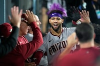 Arizona Diamondbacks' Lourdes Gurriel Jr. celebrates with teammates in the dugout after his solo home run during the sixth inning in Game 2 of a baseball NL Division Series against the Los Angeles Dodgers, Monday, Oct. 9, 2023, in Los Angeles. (AP Photo/Ashley Landis)
