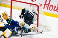 Seattle Kraken's Andrew Poturalski (12) scores on Vancouver Canucks goaltender Casey DeSmith (29) during the first period of an NHL preseason game in Abbotsford, B.C. on Wednesday, Oct. 4, 2023. THE CANADIAN PRESS/Ethan Cairns