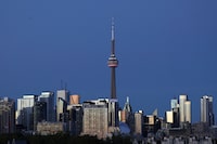 FILE PHOTO: The CN Tower stands at dusk above office buildings and condominiums in the downtown core of Toronto, Ontario, Canada September 20, 2020. REUTERS/Chris Helgren/File Photo