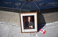 A framed portrait of former prime minister Brian Mulroney leans against the Centennial Flame on Parliament Hill  
as Canadians mourn his death at the age of 84, in Ottawa, on Friday, March 1, 2024. A state funeral for former prime minister Mulroney will be held on March 23 in Montreal.