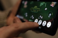 Canada's financial intelligence agency warns that illicit cash is being laundered through online gambling sites that offer a variety of ways to disguise shady funds. A "deal" button on a casino app is shown on a smartphone in a photo illustration made in Toronto, Wednesday, Jan. 17, 2024. THE CANADIAN PRESS/Giordano Ciampini