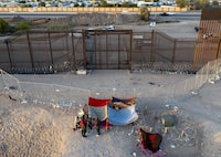 FILE - A small group of migrants are pictured while camping outside a gate in the border fence in El Paso, Texas, Friday, May 12, 2023. Migrant children in makeshift camps along the U.S.-Mexico border who are waiting to be processed by Border Patrol are in the agency's custody _ something the agency had denied _ and said the Department of Homeland Security must quickly process them and place them in facilities that are “safe and sanitary.” (AP Photo/Andres Leighton, File)