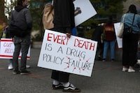 A protester holds a sign during a rally in Victoria, Thursday, April 14, 2022. The BC Coroners Service says 184 people died in B.C. in June due to the toxic, unregulated drug supply that has claimed more than 1,200 lives in the first six months of 2023. The coroners service says the numbers show just how risky it continues to be for users who access their drugs on the illicit market. THE CANADIAN PRESS/Chad Hipolito