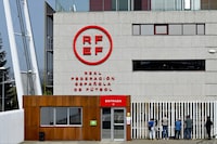 Journalists stand outside the headquarters of the Spanish Royal Football Federation (RFEF) in Las Rozas de Madrid on March 20, 2024 during a police search. Spanish police searched the Spanish football federation (RFEF) headquarters and other locations as part of an investigation into alleged corruption and other crimes, judicial sources said March 20, 2024. According to Spanish media the operation is part of a court investigation into contracts signed by former federation president to take the Spanish Super Cup to Saudi Arabia. (Photo by JAVIER SORIANO / AFP) (Photo by JAVIER SORIANO/AFP via Getty Images)