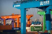 File - A crane lifts a shipping container at an automated container port in Tianjin, China, Jan. 16, 2023. The global economy, which has proved surprisingly resilient this year, is expected to falter next year under the strain of wars, still-elevated inflation and continued high interest rates. (AP Photo/Mark Schiefelbein, File)
