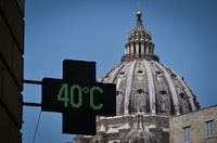 (FILES) This photograph taken on July 19, 2023, shows a pharmacy's sign indicating the current outside temperature is 40 degrees celsius, with the dome of Saint Peter Basilica in the background, in Rome amid a heatwave in Italy. The year of 2023 was the hottest on record, with the increase in Earth's surface temperature nearly crossing the critical threshold of 1.5 degrees Celsius, EU climate monitors said on January 9, 2023. Climate change intensified heatwaves, droughts and wildfires across the planet, and pushed the global thermometer 1.48 C above the preindustrial benchmark, the Copernicus Climate Change Service (C3S) reported. (Photo by Tiziana FABI / AFP) (Photo by TIZIANA FABI/AFP via Getty Images)