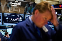 FILE PHOTO: The Goldman Sachs logo is pictured above a trader on the floor of the New York Stock Exchange shortly after the opening bell in the Manhattan borough of New York April 2, 2014.  REUTERS/Lucas Jackson (UNITED STATES - Tags: BUSINESS LOGO)/File Photo
