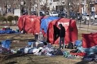 A person cleans out a tent at the homeless encampment in Victoria Park in Halifax's downtown on Monday, March 4, 2024. A fence was erected around the perimeter of the park Monday morning as officials began working with the few remaining residents to leave the de-designated encampment site. THE CANADIAN PRESS/Darren Calabrese