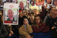 Demonstrators lift portraits of Elad Katzir during a protest for relatives and supporter of Israeli hostages held in Gaza since the October 7 attacks by Palestinian Hamas militants, during a rally calling for their release in Tel Aviv on February 3, 2024. (Photo by AHMAD GHARABLI / AFP) (Photo by AHMAD GHARABLI/AFP via Getty Images)