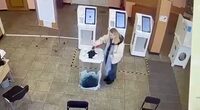 A woman pours a liquid into a ballot box, during the Russian presidential election in Moscow, Russia, in this screen grab taken from a video recording of a screen showing CCTV footage, March 15, 2024. Video obtained by Reuters/via REUTERS