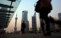 People walk along an elevated walkway at the Pudong financial district in Shanghai Nov. 20, 2013.